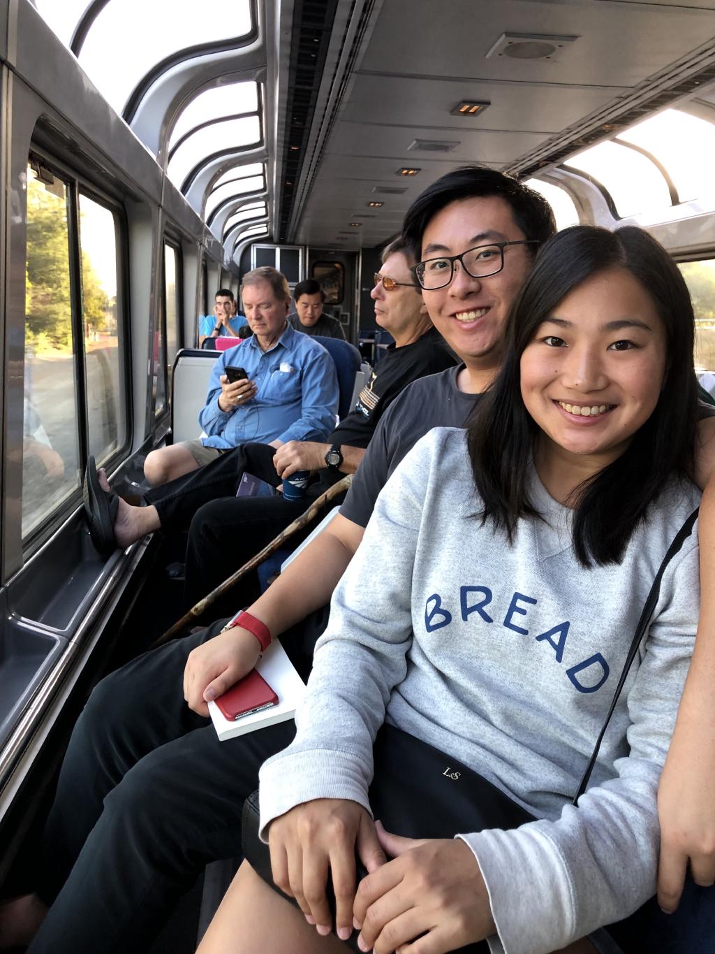 Kelly and Eric in a train car with windows passing through California